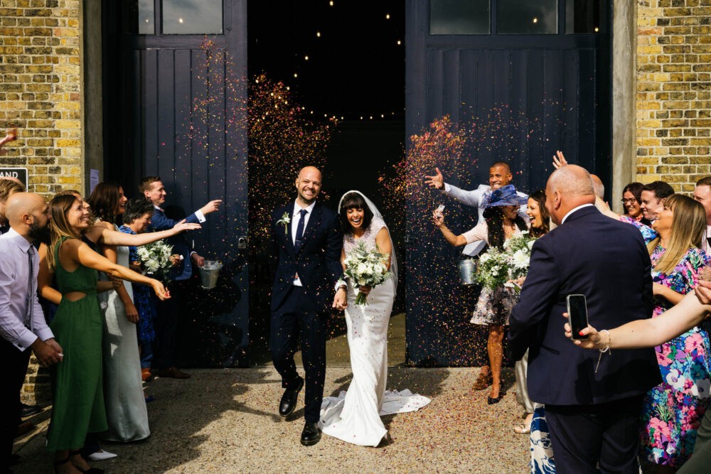 couple exit the ceremony at the  chainstore at Trinity Buoy Wharf  into confetti